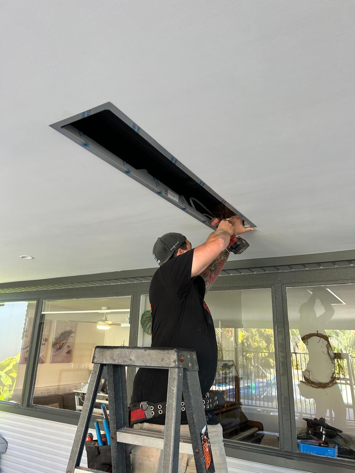 Mylec electrician fitting a roof light fixture in Shell Cove, NSW